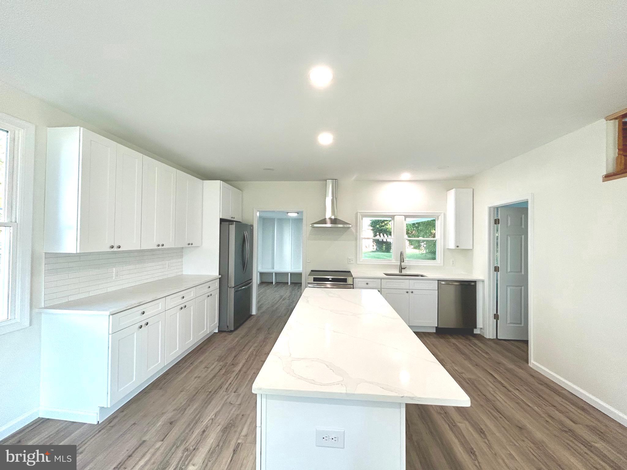 a large kitchen with cabinets and wooden floor