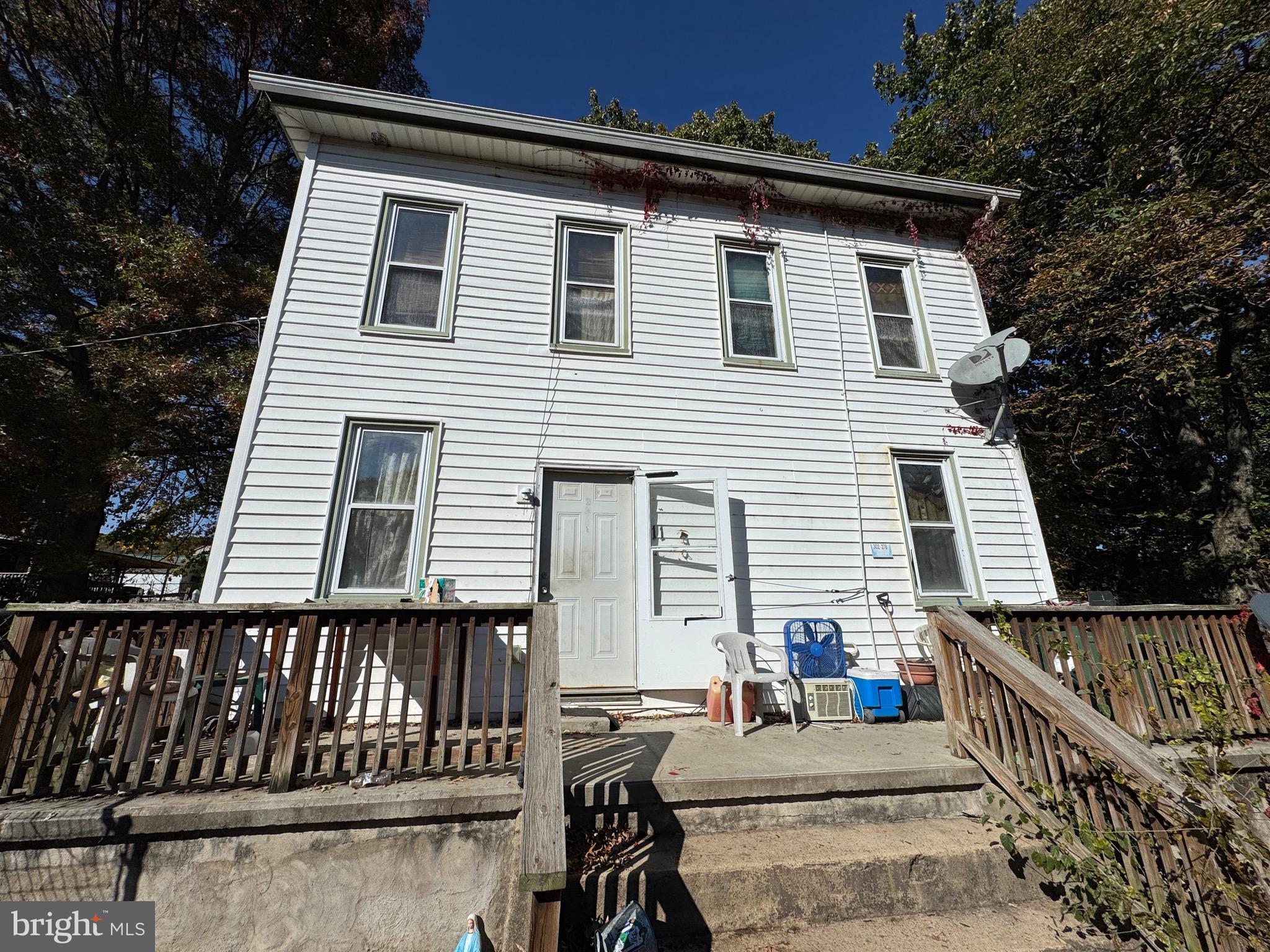 a view of a house with wooden deck and furniture