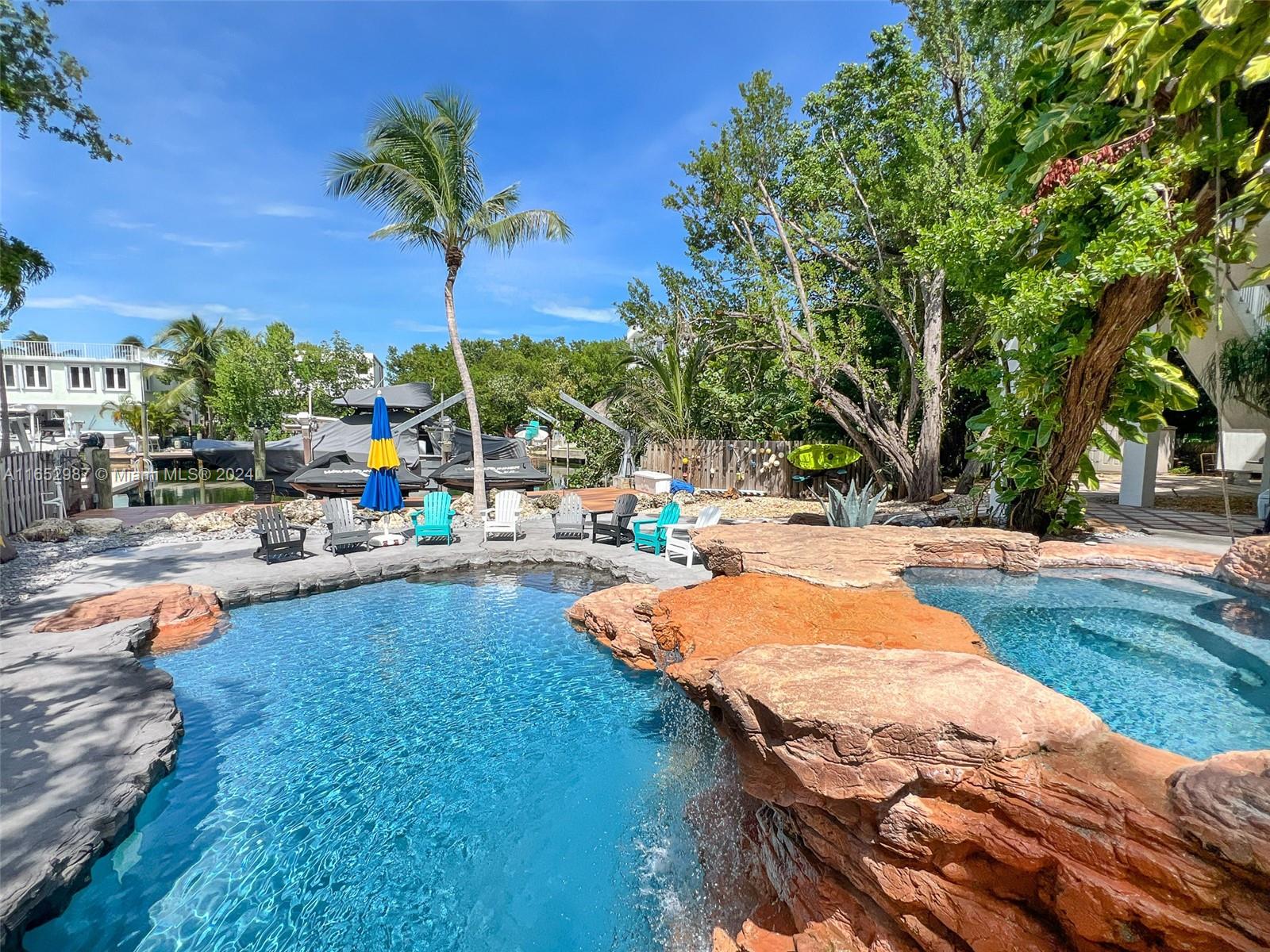 a view of a swimming pool with a patio and a yard