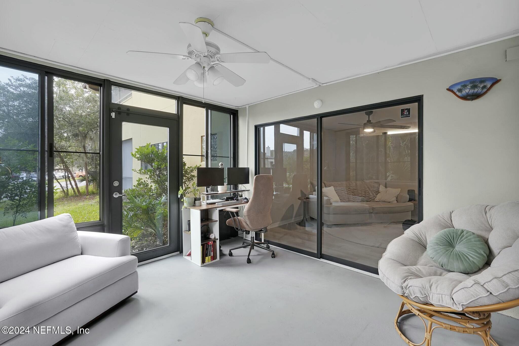 a living room with furniture floor to ceiling window and a floor to ceiling window