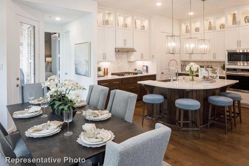 a kitchen with stainless steel appliances kitchen island granite countertop a dining table and chairs