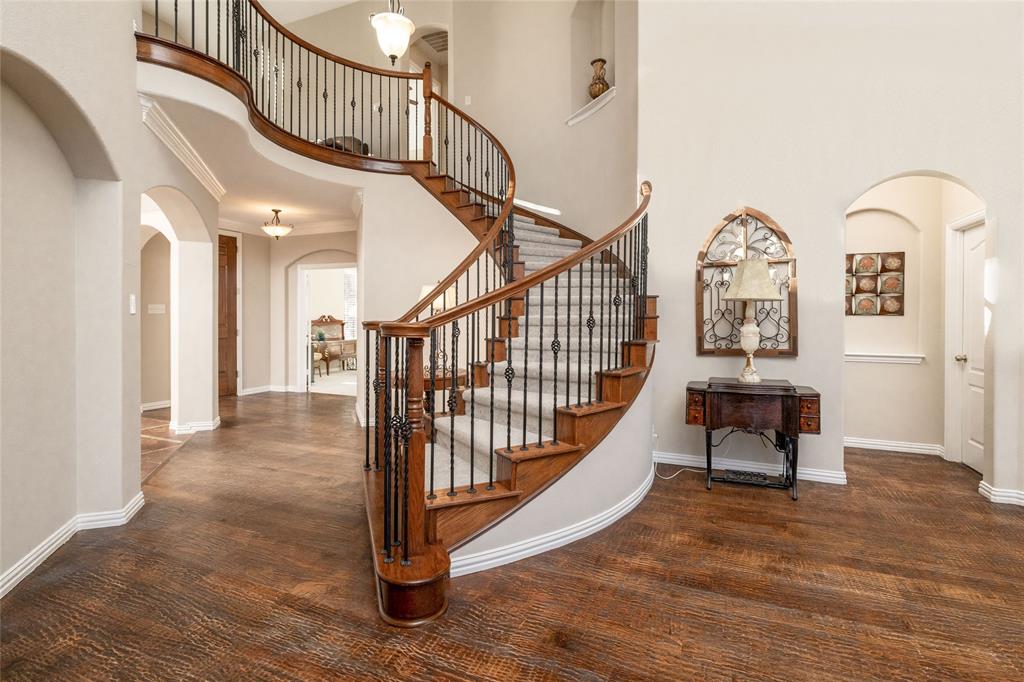 a view of staircase with lots of frames on wall and a table