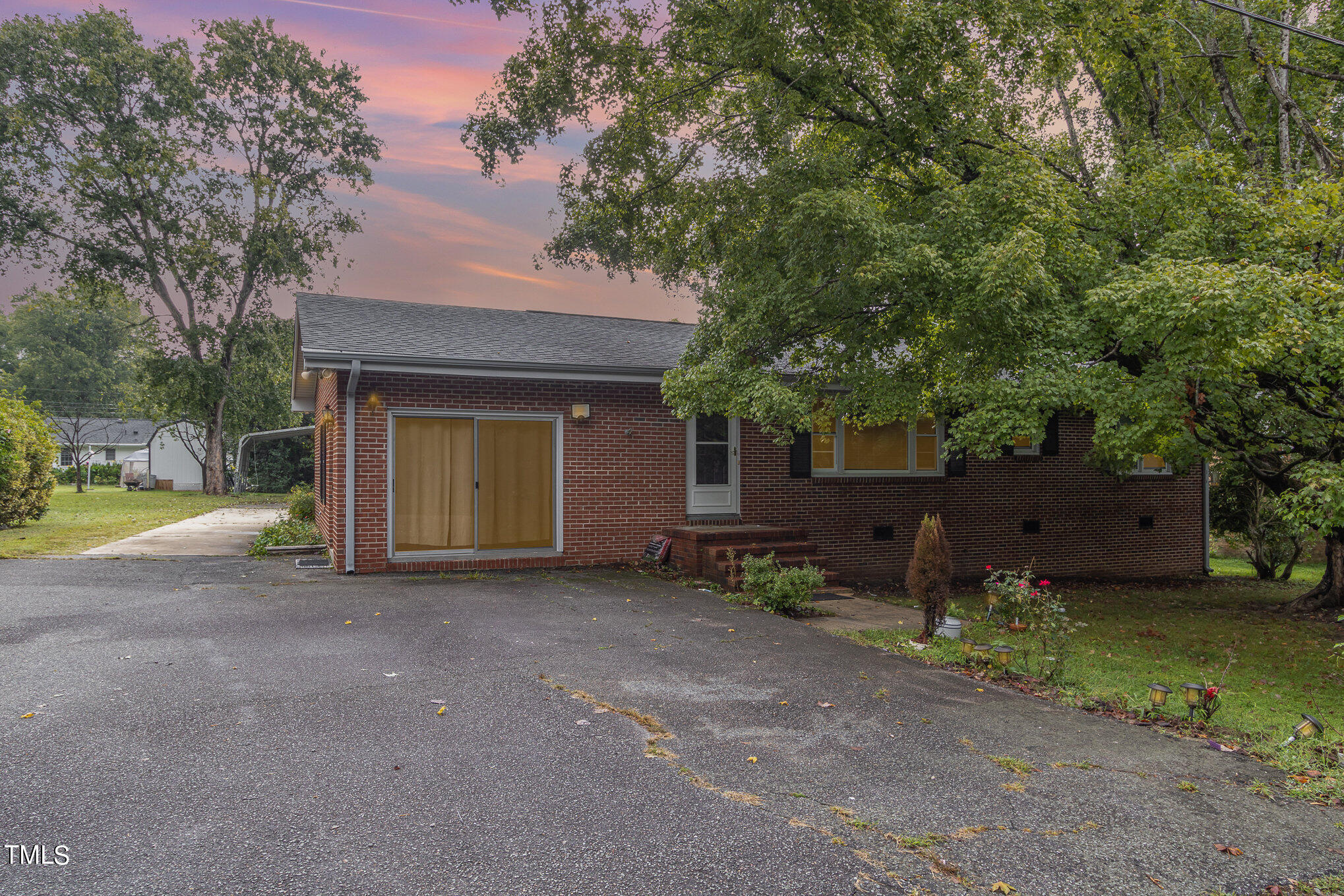 a view of a house with a yard and large tree