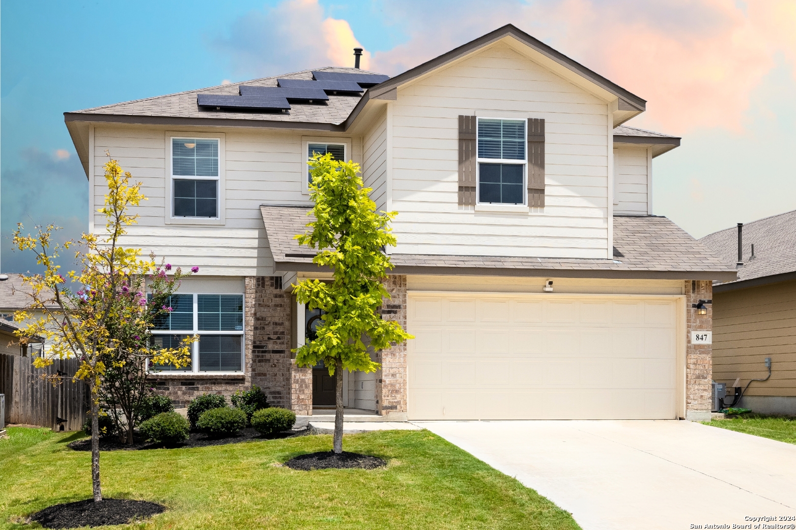 a front view of a house with a yard and garage