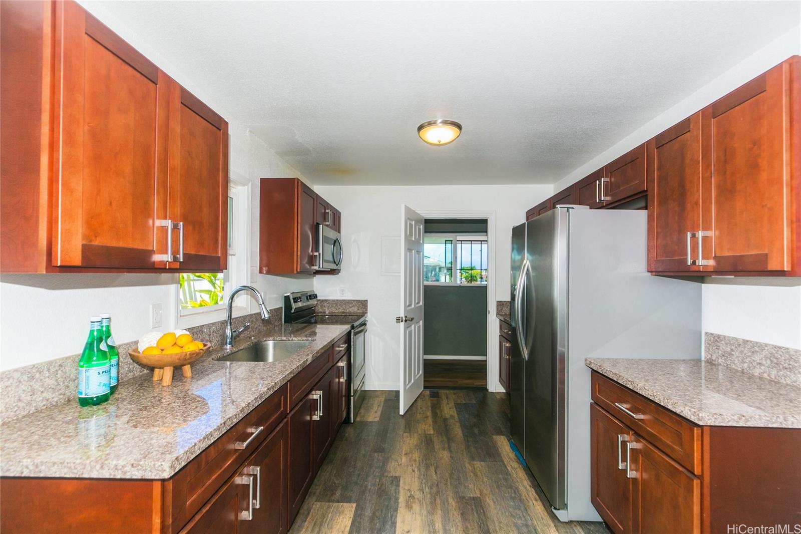 a kitchen with stainless steel appliances granite countertop a sink stove and refrigerator