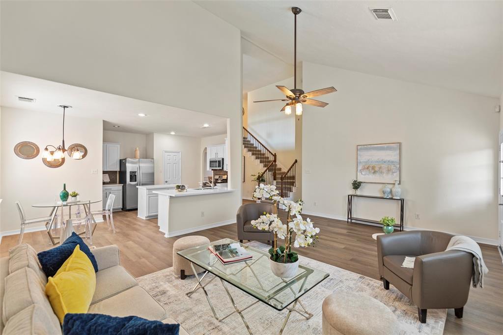 a living room with furniture kitchen view and a chandelier