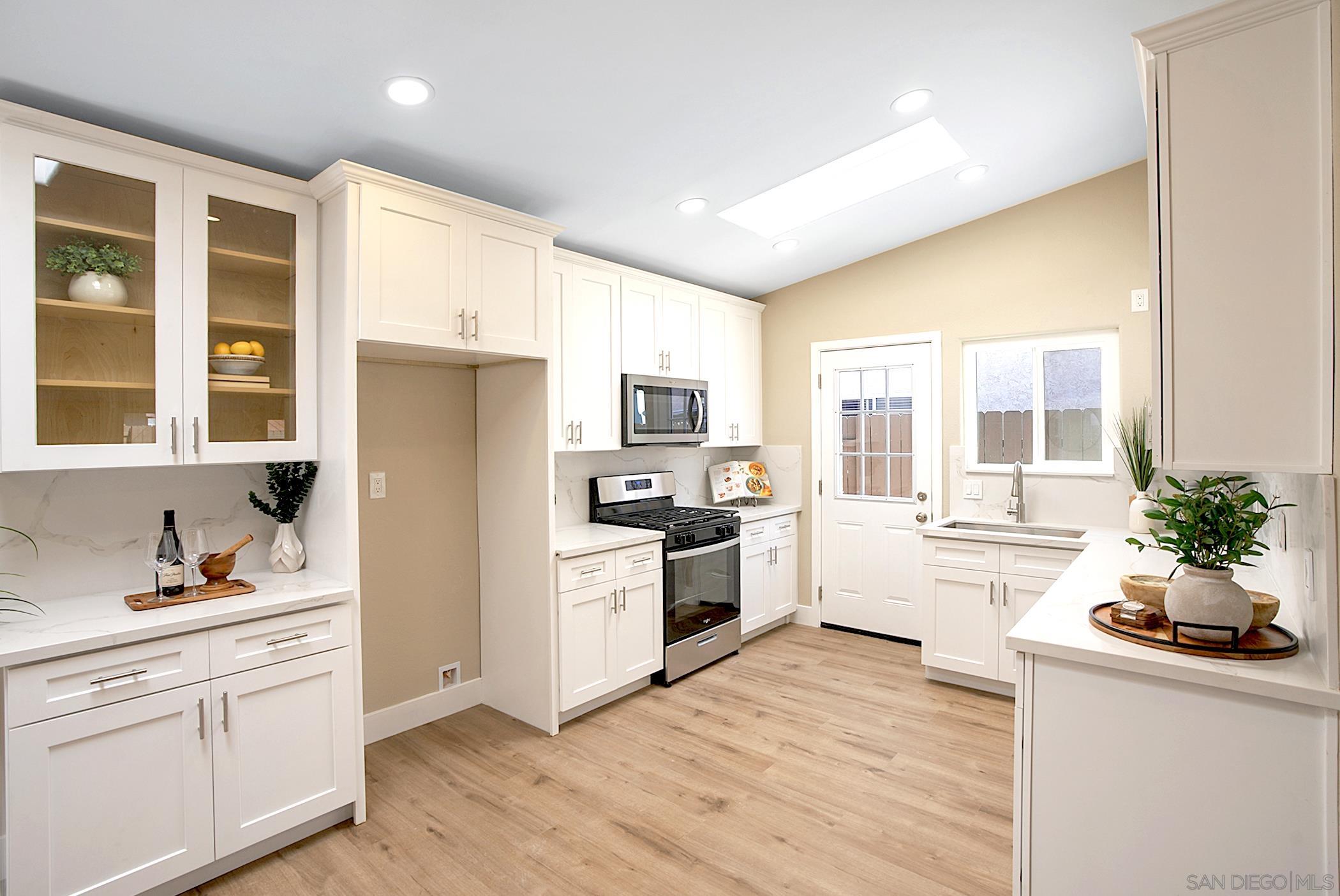 a kitchen with white cabinets and stainless steel appliances