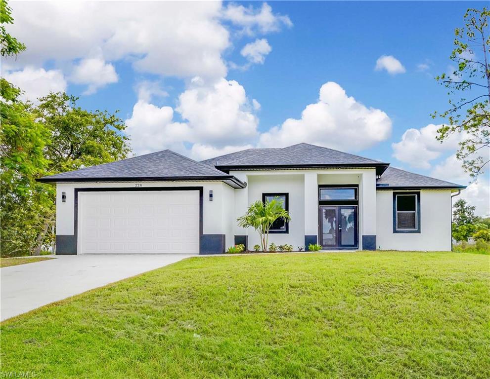 View of front of house featuring a front lawn and a garage