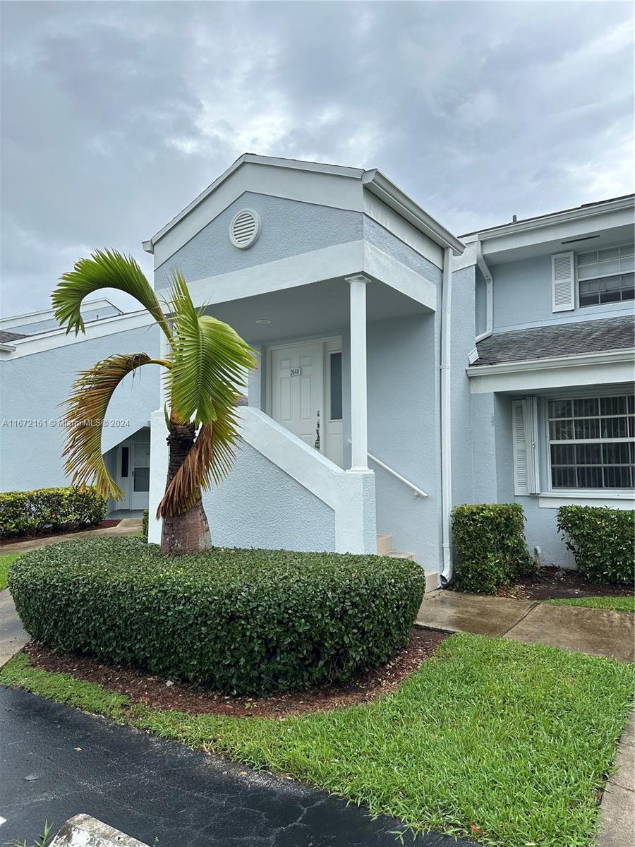 a front view of a house with a garden