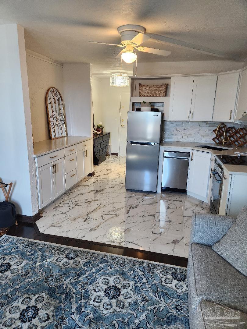 a kitchen with stainless steel appliances granite countertop a sink a stove a washer and dryer