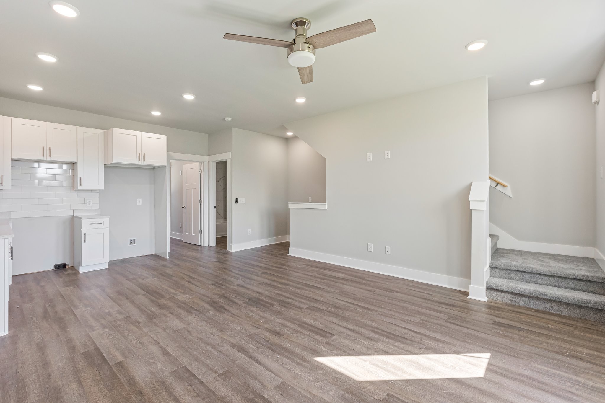 wooden floor in an empty room with a kitchen