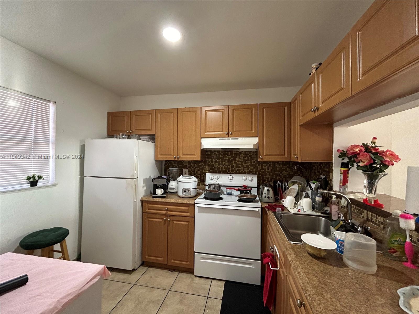 a kitchen with a sink dishwasher stove and refrigerator with wooden floor