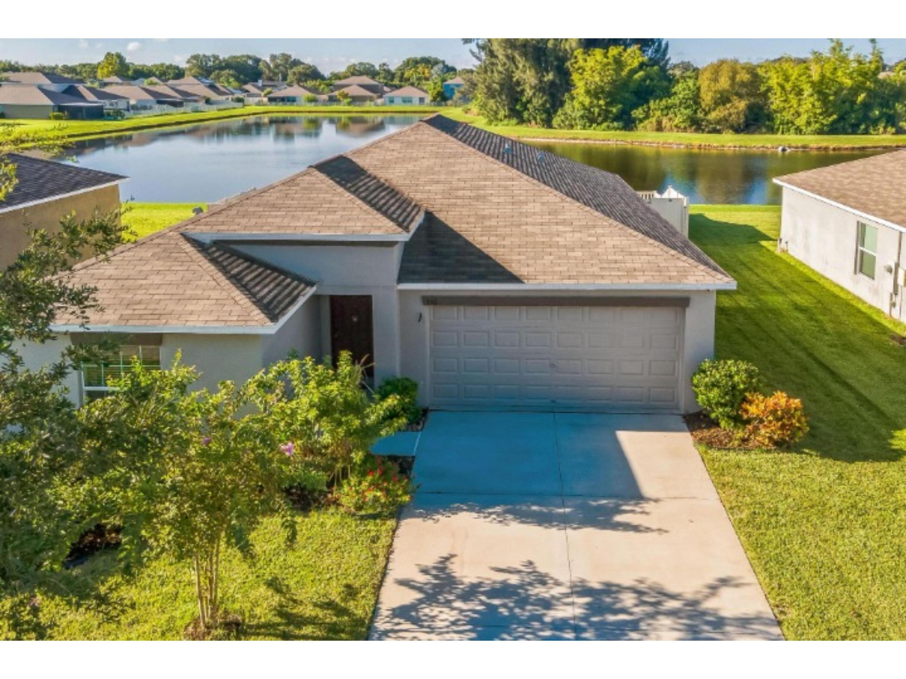 a aerial view of a house with a yard and a lake view