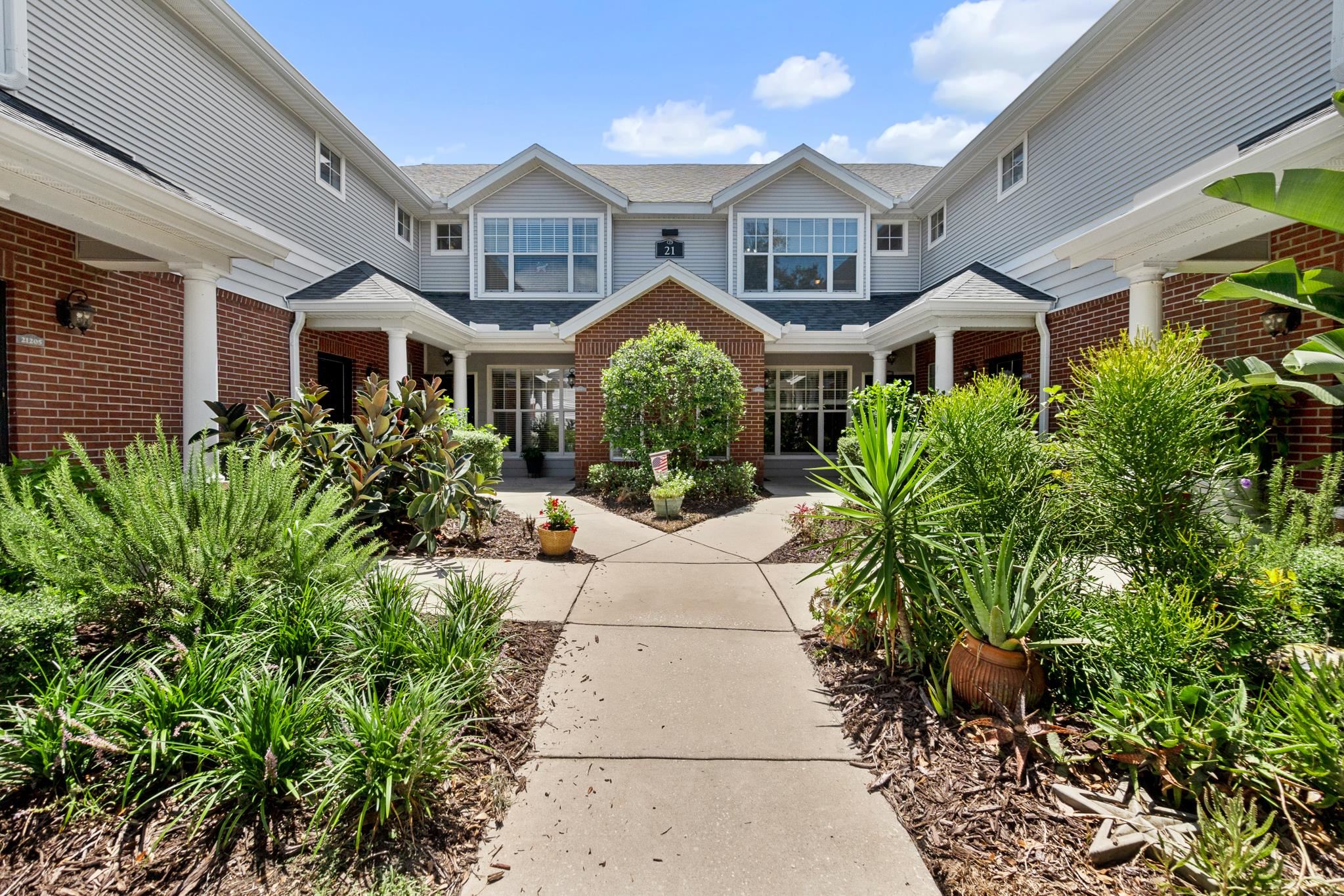 a front view of a building with a garden