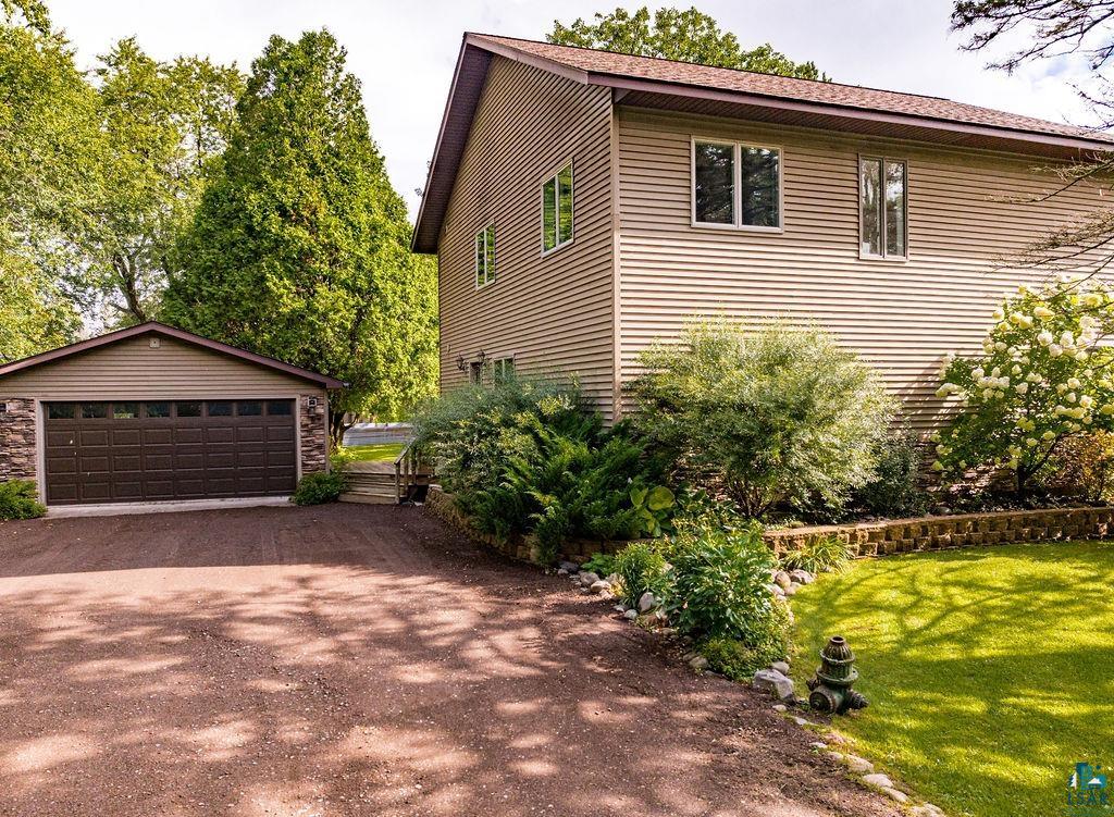 View of side of property featuring a lawn and a garage