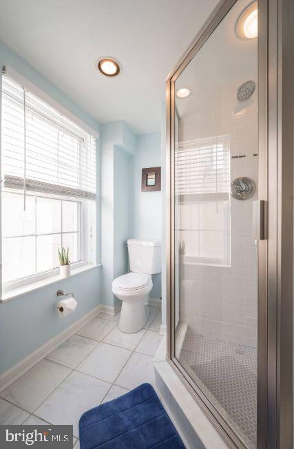 a bathroom with a toilet and a shower