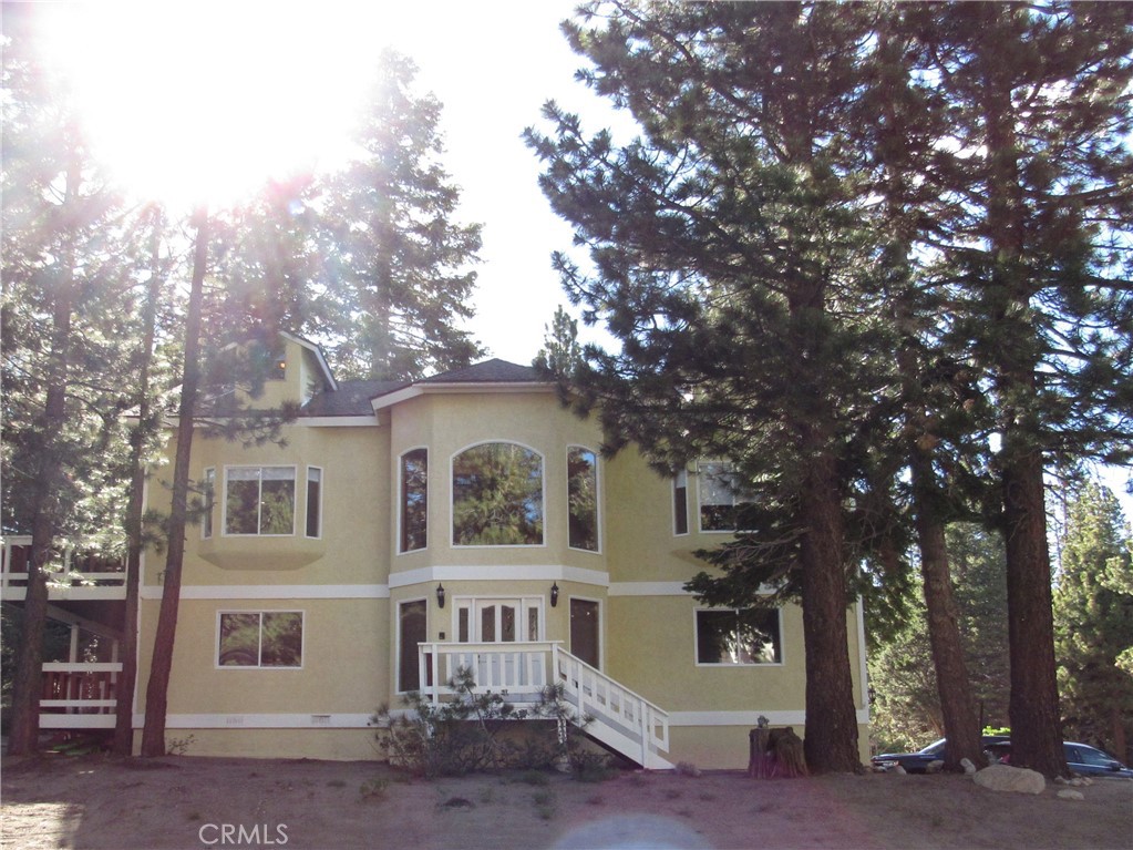 a front view of a house with a tree