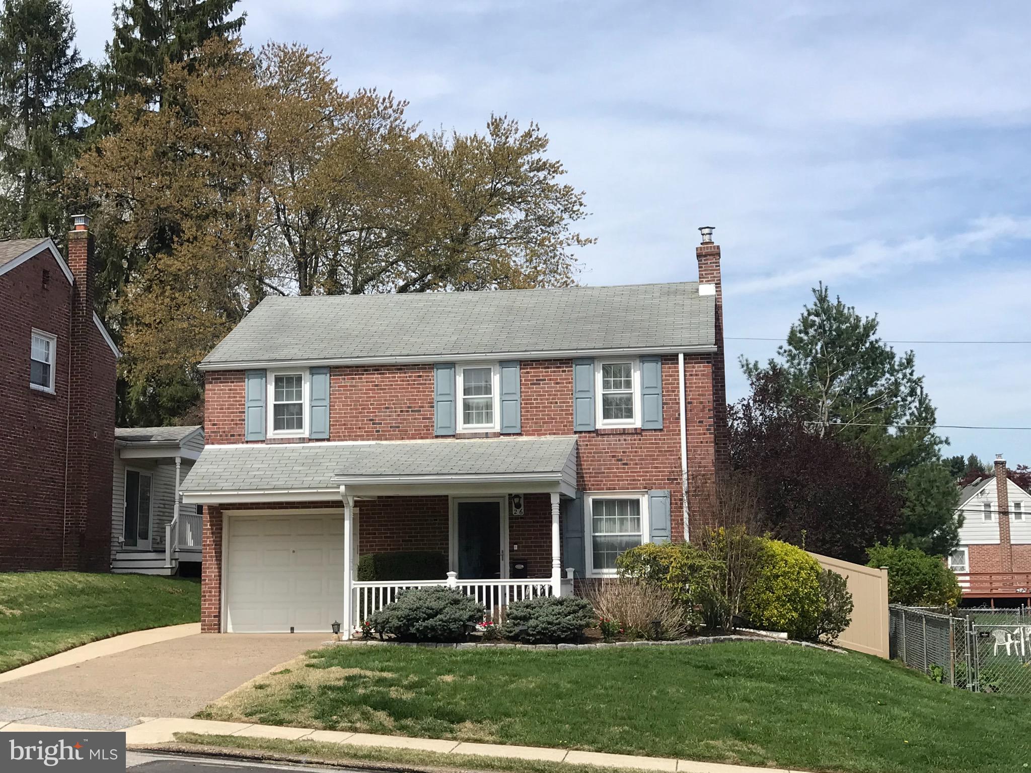 a front view of a house with a yard and trees