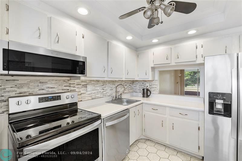 a kitchen with a sink appliances and cabinets