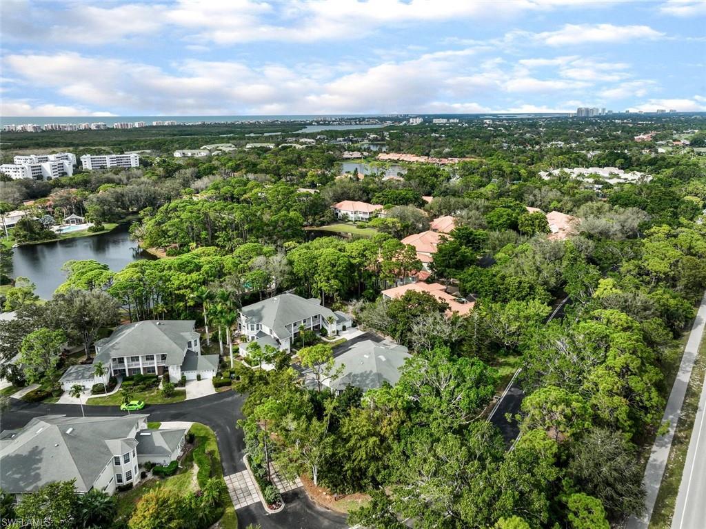 an aerial view of a city with lots of residential buildings ocean and mountain view in back