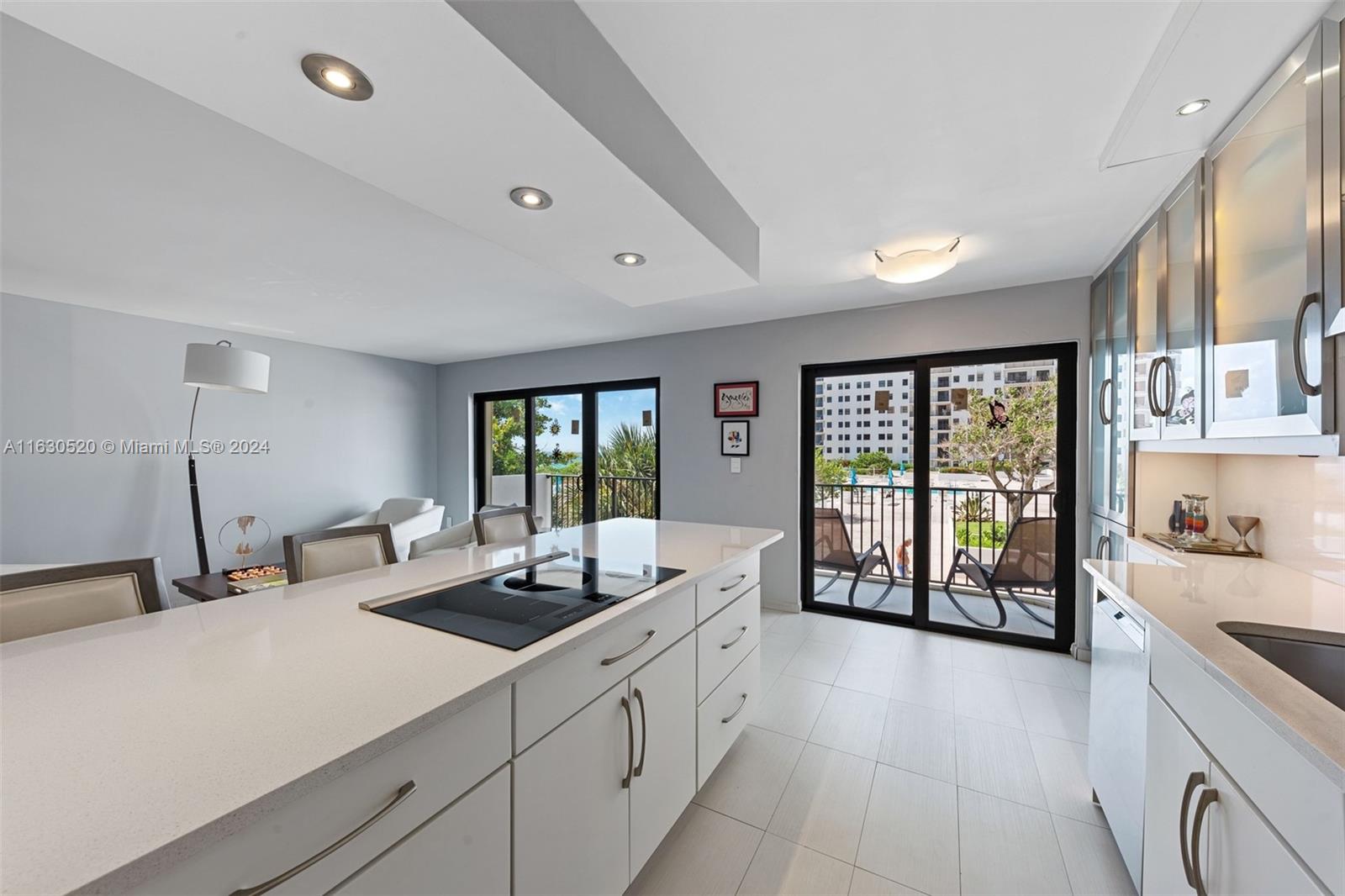 a large white kitchen with a large window and stainless steel appliances