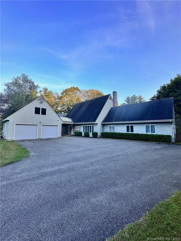 a view of a house with a yard and large tree