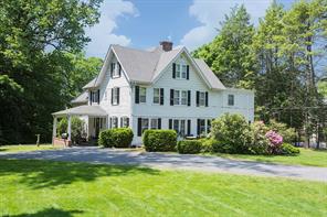 a front view of a house with a yard and trees