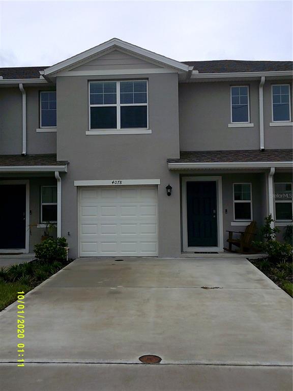 a front view of a house with yard and parking