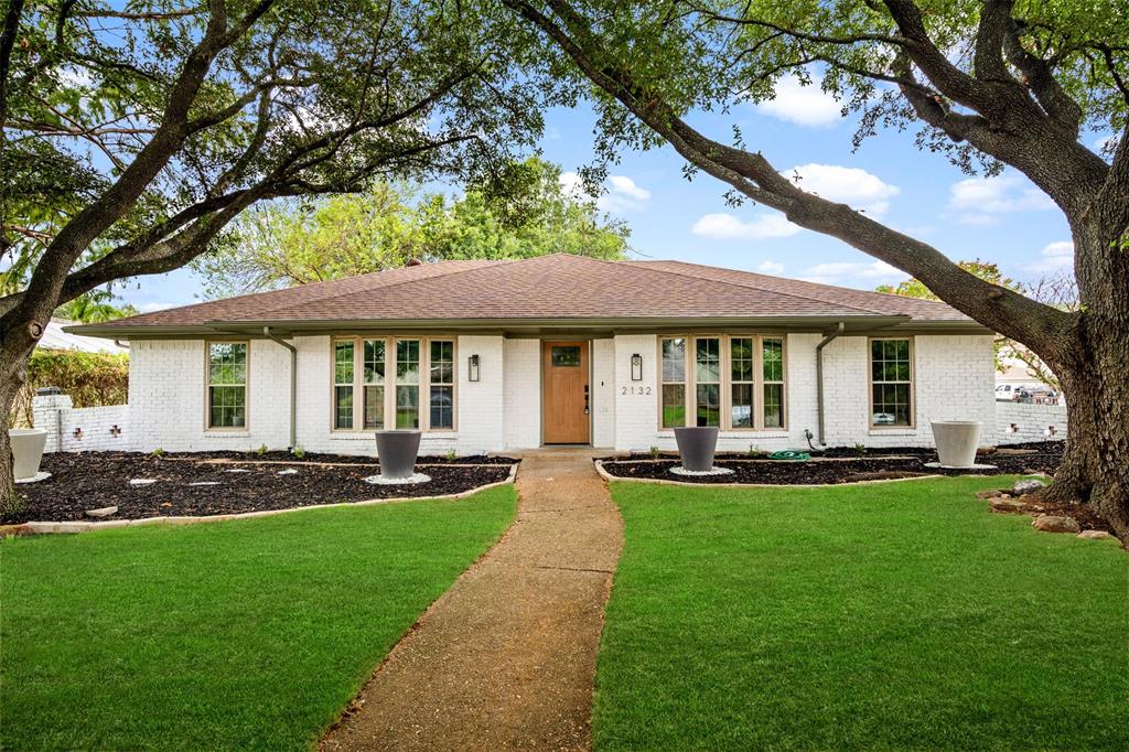 a view of a house with a yard porch and a large tree