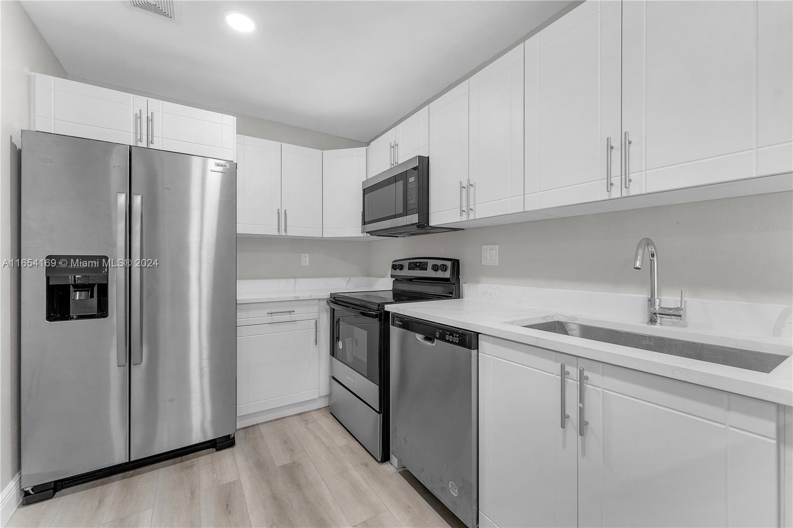 a kitchen with cabinets stainless steel appliances and a sink