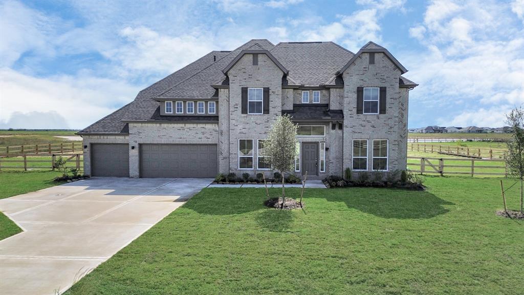 a view of a big house with a big yard and large trees