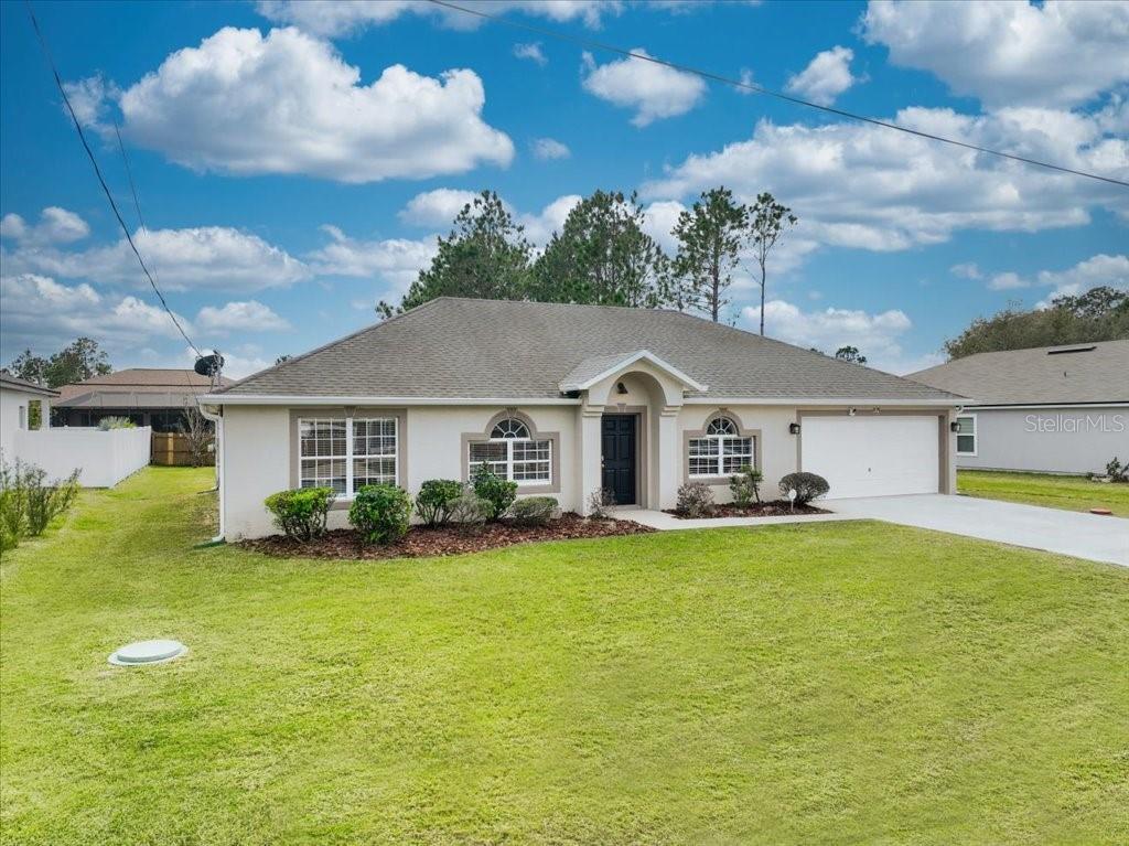 a front view of a house with a garden and yard