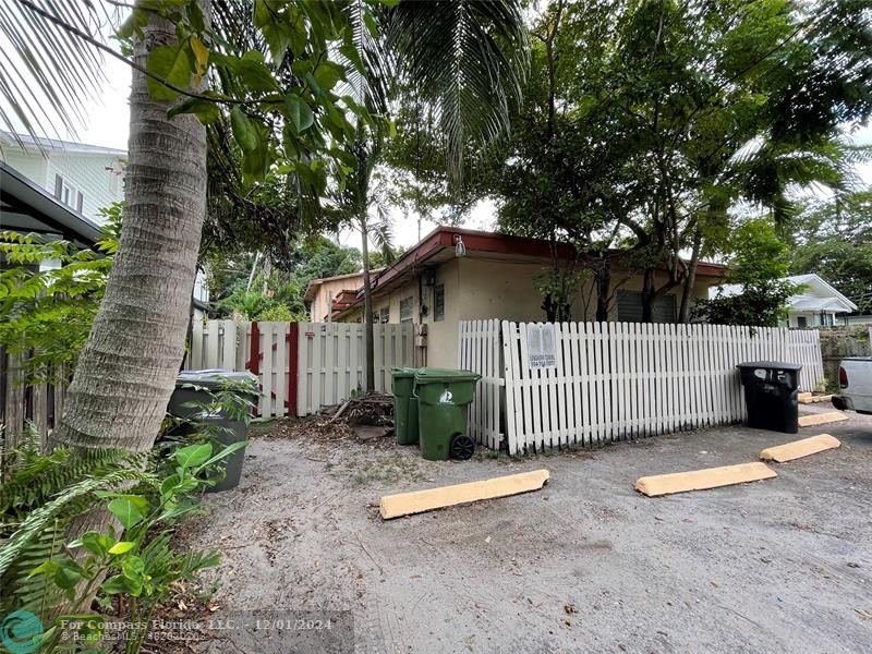 a view of a house with a small yard and wooden fence