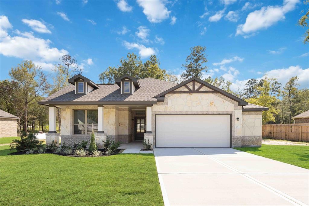 a front view of a house with a yard and garage