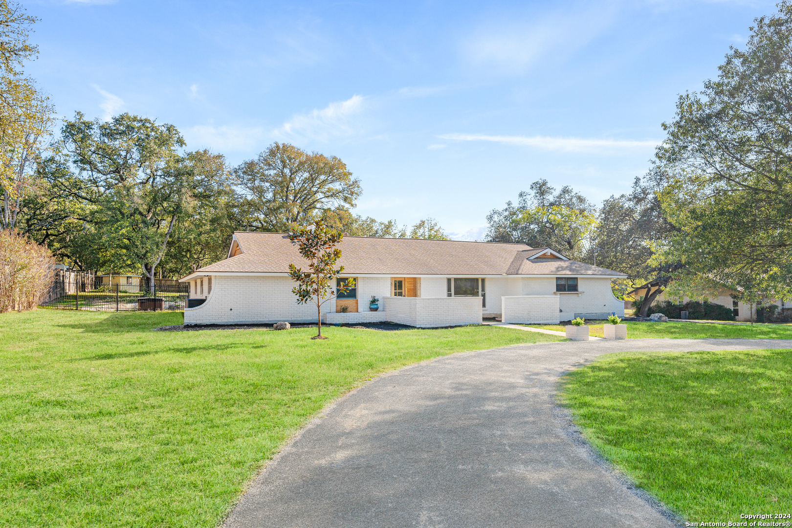 a front view of a house with a yard and trees