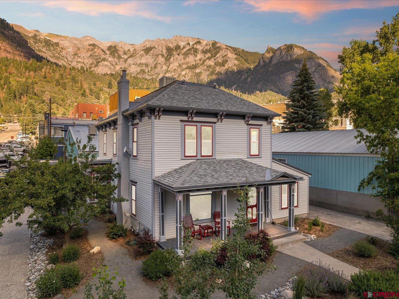 an aerial view of a house with a yard and mountain view in back