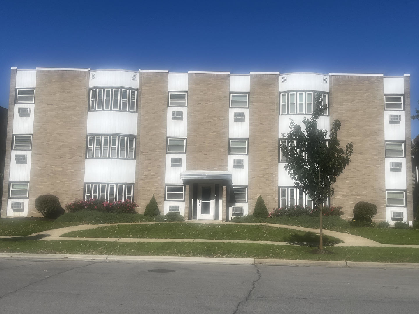 a front view of a residential apartment building with a yard