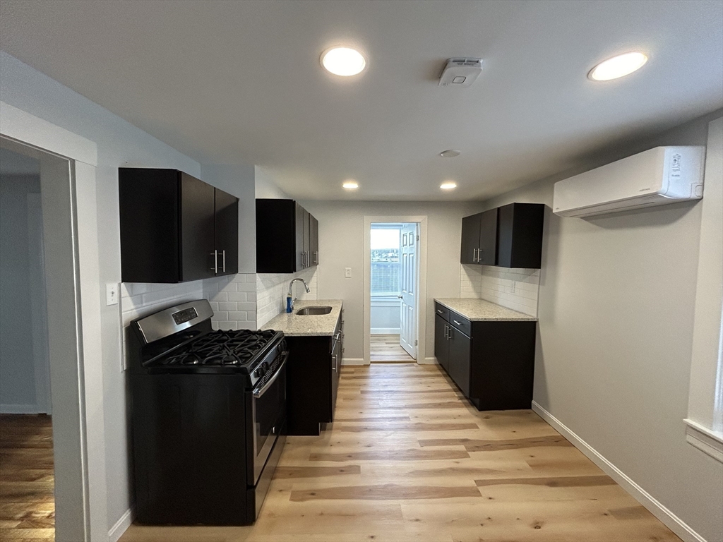 a kitchen with stainless steel appliances kitchen island granite countertop a stove and a refrigerator