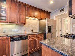 a kitchen with stainless steel appliances granite countertop a sink a stove and a refrigerator