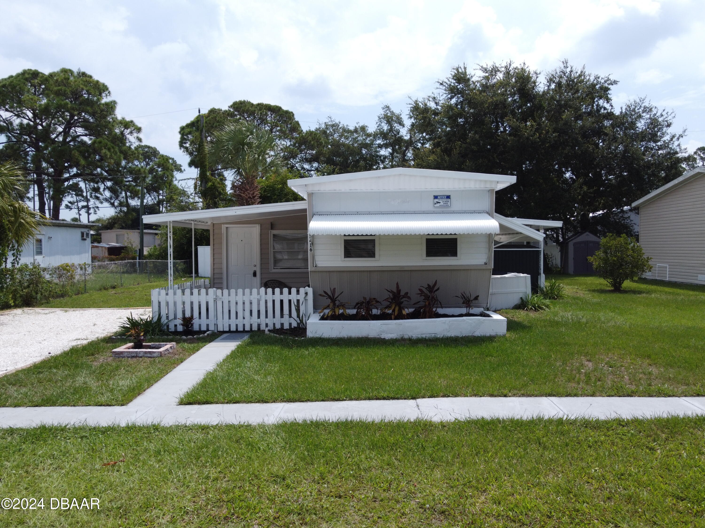 a view of a house with a big yard and potted plants