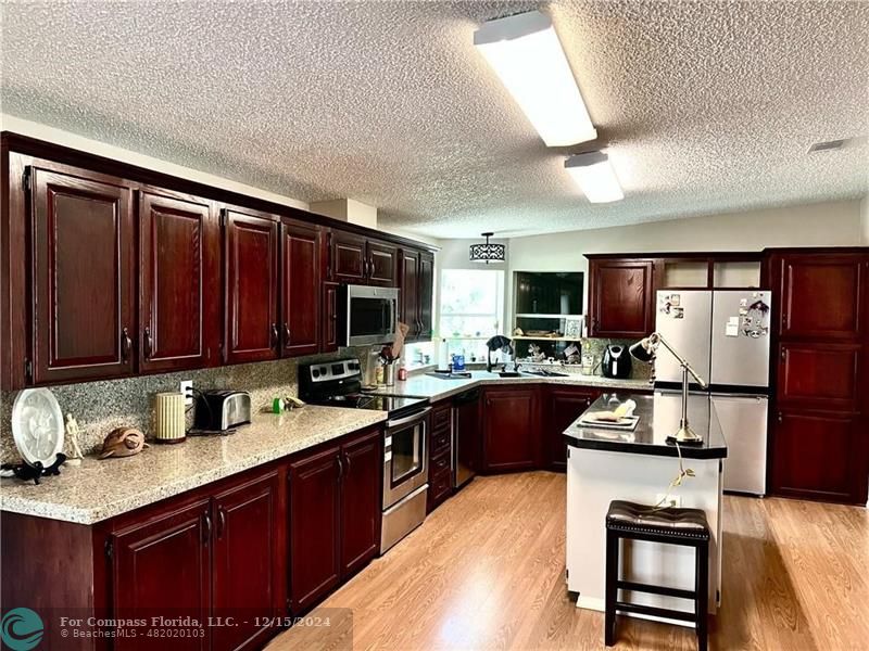 a kitchen with granite countertop stainless steel appliances and wooden cabinets