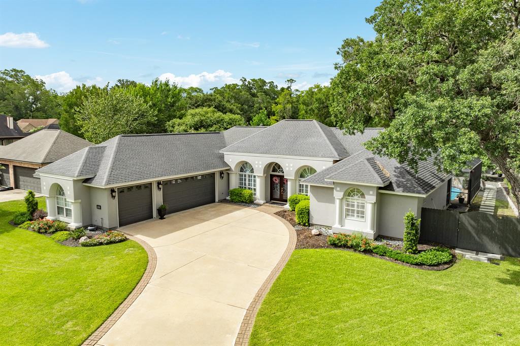 a aerial view of a house with yard and a large tree