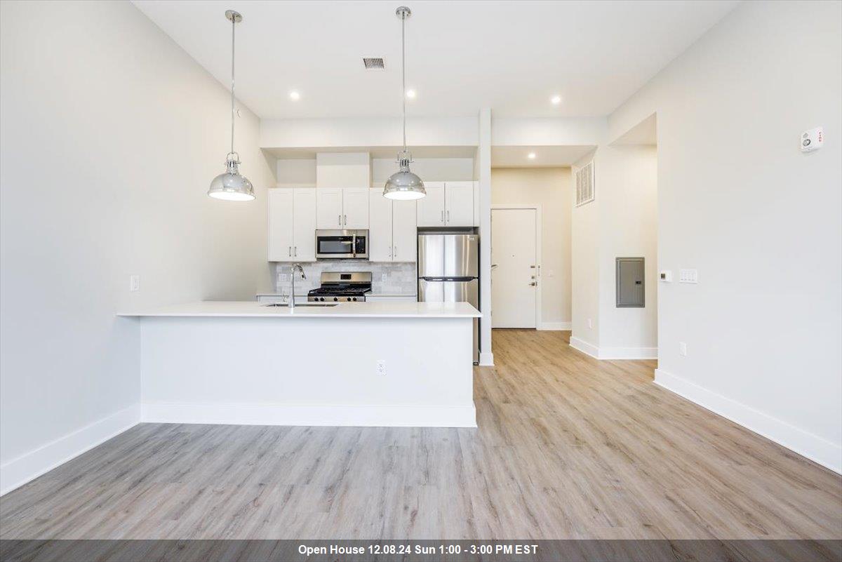 a view of kitchen with cabinets wooden floor and kitchen view