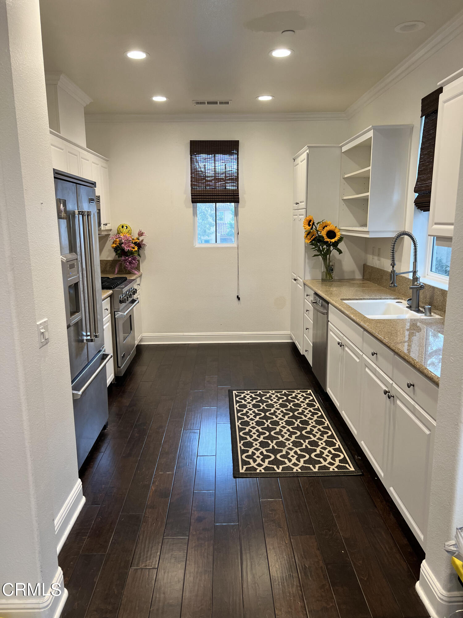 a kitchen with stainless steel appliances a refrigerator sink and stove