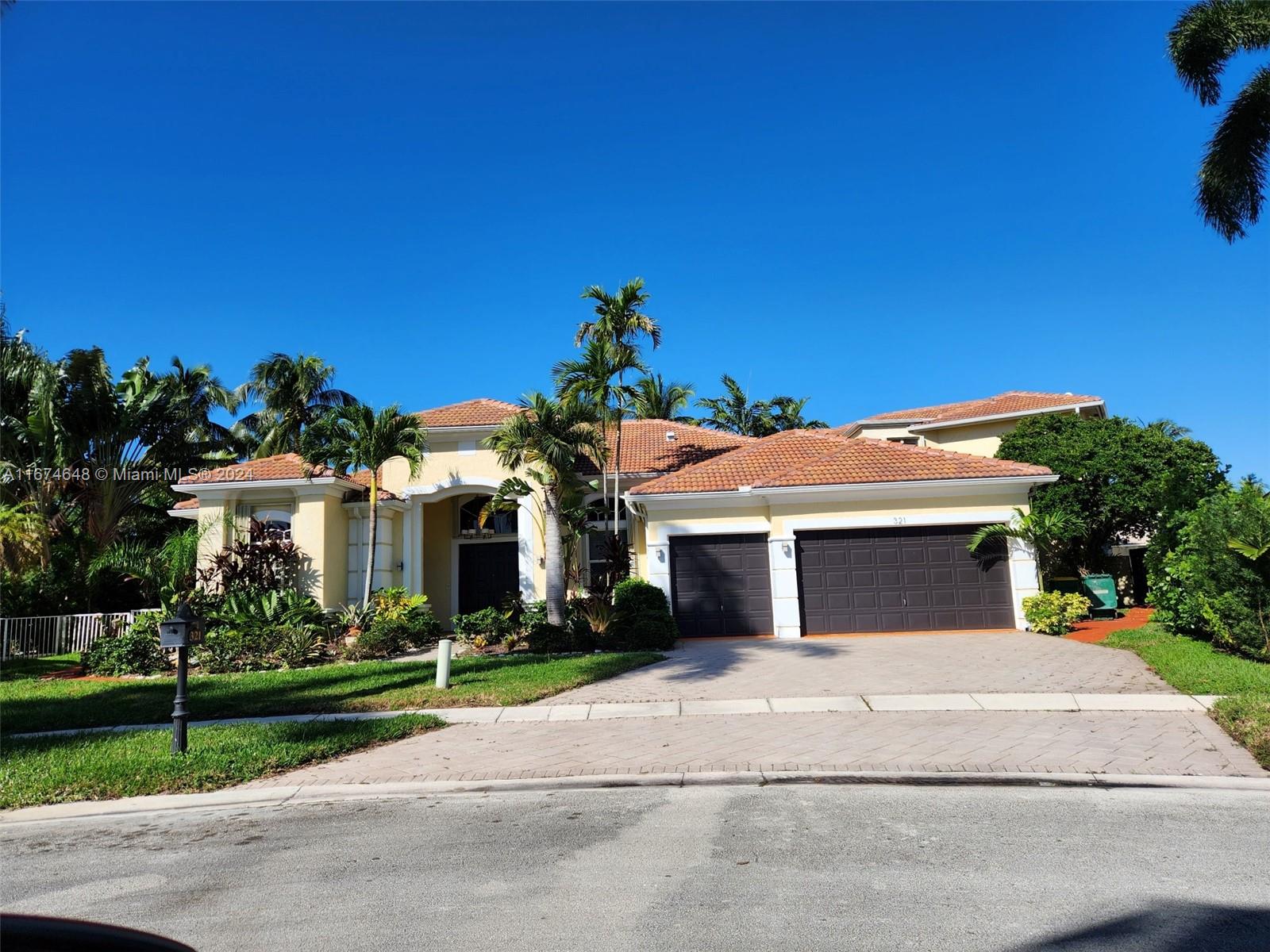 a front view of a house with a yard and potted plants