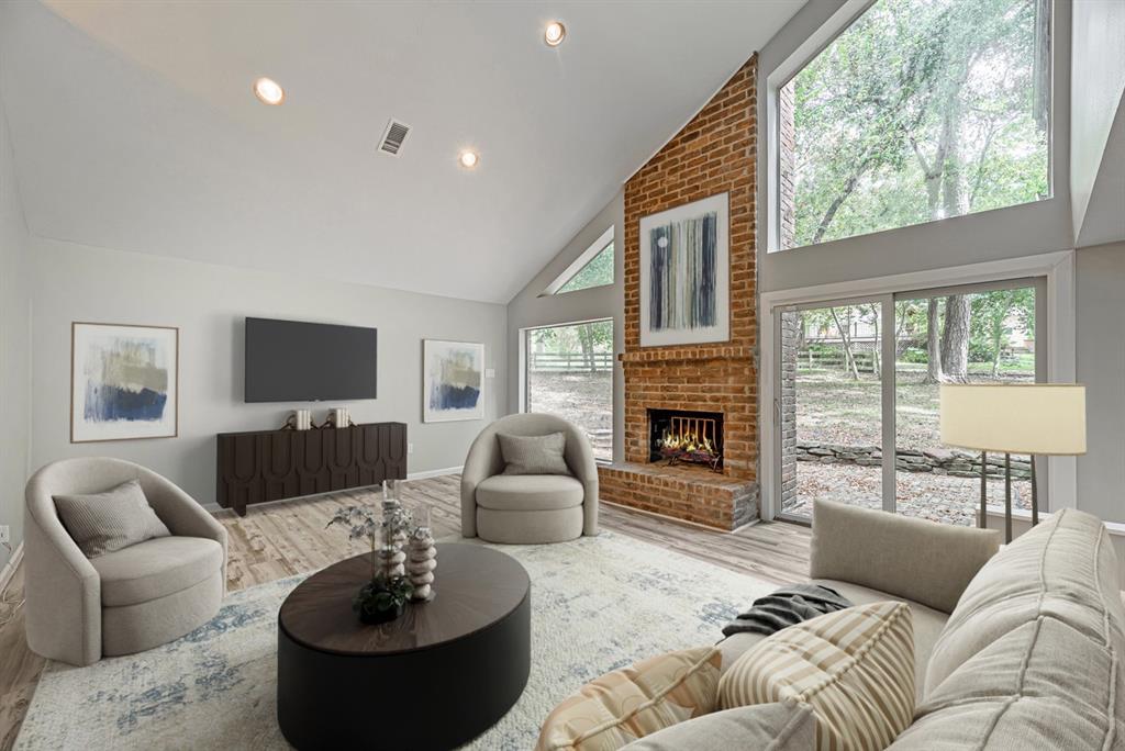 a living room with furniture a fireplace and a large window