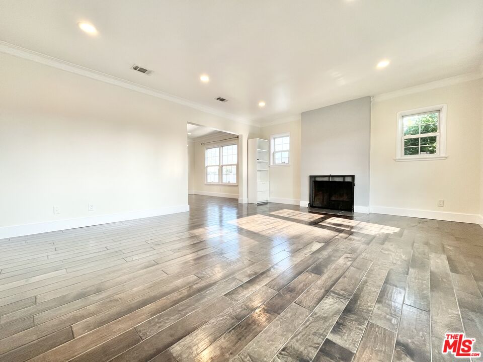 a view of empty room with wooden floor and fireplace