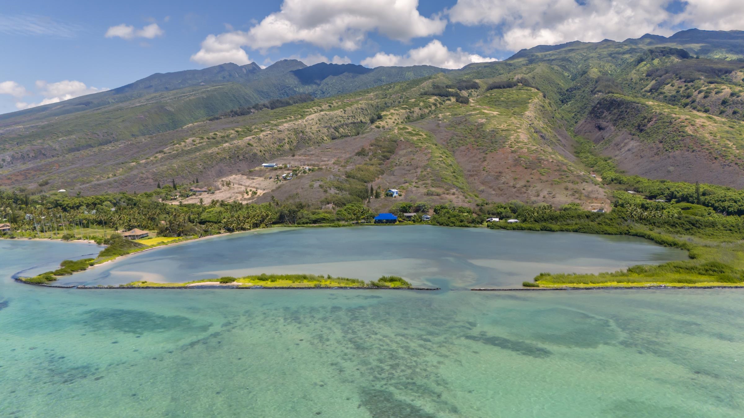 an aerial view of a house with a garden and lake view