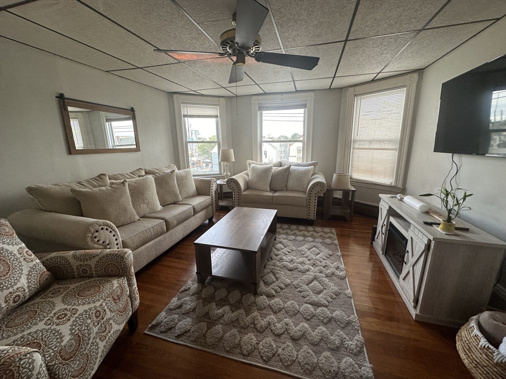 a living room with furniture a flat screen tv and a window