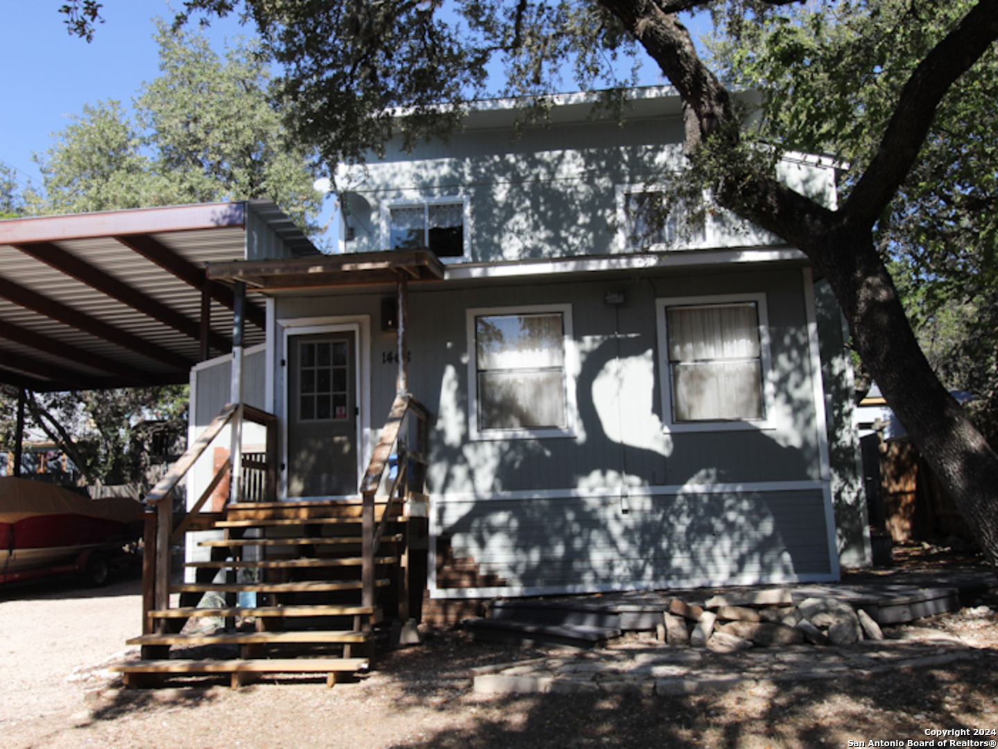 a front view of a house with a tree